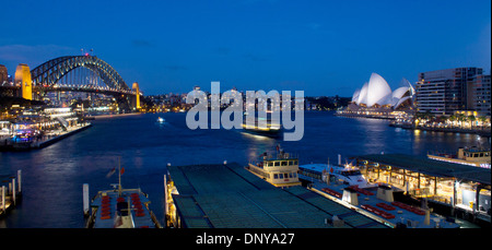 Il Circular Quay di notte con i traghetti arrivano, Harbour Bridge e Opera House Sydney New South Wales NSW Australia Foto Stock