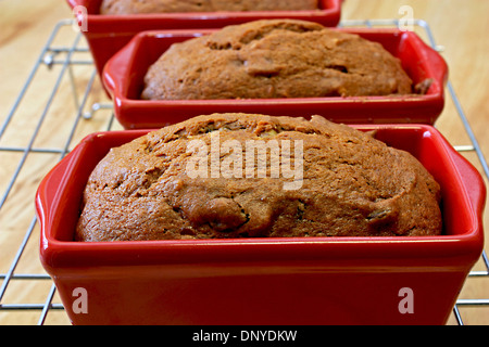 La zucca chocolate chip pane in rosso focaccia padelle raffreddare su una griglia sul tavolo di cucina dolce da forno Foto Stock