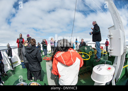 Antartide - passeggeri e dell equipaggio raccogliere esterno per il tè del pomeriggio sul ponte della Polar Pioneer in Fournier Bay in Antartide. Il pioniere polare è un russo antighiaccio nave operati dalla compagnia australiana Aurora spedizioni. Foto Stock