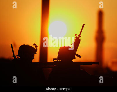 Jan 30, 2006 - Al-Falujah, Iraq - Una silhouette di marines con armi al tramonto dalla società Eco, secondo battaglione, 6 Marines, RCT-8, si siede in un Humvee durante una pattuglia della città di Falujah. (Credito Immagine: © Toby Morris/ZUMA Press) Foto Stock