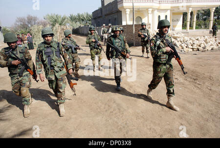 Feb 28, 2006; vicino a Ar Ramadi, Al Anbar, Iraq; un iracheno della polizia speciale Commando dal 2° Battaglione Brigata 2a, anche ampiamente noto come 'Wolf Brigata" parla ai residenti in una zona rurale appena a nord della città irachena di Ar Ramadi su Feb 28, 2006. La polizia irachena sono stati su una missione congiunta con i soldati dal 101st airbourne in cerca di presunti insorti. Credito: Foto Foto Stock