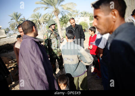 Feb 28, 2006; vicino a Ar Ramadi, Al Anbar, Iraq; un iracheno della polizia speciale Commando dal 2° Battaglione Brigata 2a, anche ampiamente noto come 'Wolf Brigata" parla ai residenti in una zona rurale appena a nord della città irachena di Ar Ramadi su Feb 28, 2006. La polizia irachena sono stati su una missione congiunta con i soldati dal 101st airbourne in cerca di presunti insorti. Credito: Foto Foto Stock