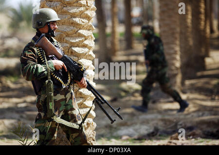Feb 28, 2006; vicino a Ar Ramadi, Al Anbar, Iraq; un iracheno della polizia speciale Commando dal 2° Battaglione Brigata 2a, anche ampiamente noto come 'Wolf Brigata" parla ai residenti in una zona rurale appena a nord della città irachena di Ar Ramadi su Feb 28, 2006. La polizia irachena sono stati su una missione congiunta con i soldati dal 101st airbourne in cerca di presunti insorti. Credito: Foto Foto Stock