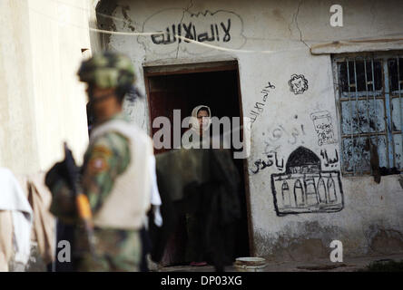 Feb 28, 2006; vicino a Ar Ramadi, Al Anbar, Iraq; un iracheno della polizia speciale Commando dal 2° Battaglione Brigata 2a, anche ampiamente noto come 'Wolf Brigata" parla ai residenti in una zona rurale appena a nord della città irachena di Ar Ramadi su Feb 28, 2006. La polizia irachena sono stati su una missione congiunta con i soldati dal 101st airbourne in cerca di presunti insorti. Credito: Foto Foto Stock