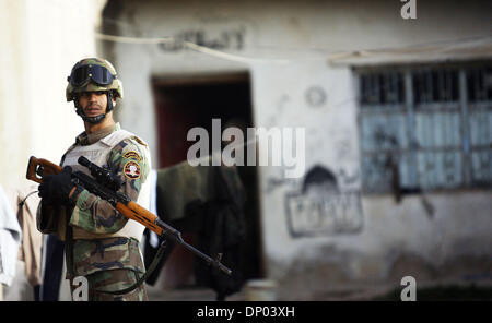Feb 28, 2006; vicino a Ar Ramadi, Al Anbar, Iraq; un iracheno della polizia speciale Commando dal 2° Battaglione Brigata 2a, anche ampiamente noto come 'Wolf Brigata" parla ai residenti in una zona rurale appena a nord della città irachena di Ar Ramadi su Feb 28, 2006. La polizia irachena sono stati su una missione congiunta con i soldati dal 101st airbourne in cerca di presunti insorti. Credito: Foto Foto Stock