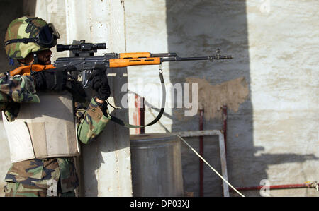 Feb 28, 2006; vicino a Ar Ramadi, Al Anbar, Iraq; un iracheno della polizia speciale Commando dal 2° Battaglione Brigata 2a, anche ampiamente noto come 'Wolf Brigata" prende la mira attraverso il suo ambito di applicazione in una zona rurale appena a nord della città irachena di Ar Ramadi su Feb 28, 2006. La polizia irachena sono stati su una missione congiunta con i soldati dal 101st airbourne in cerca di presunti insorti. Obbligatorio Credi Foto Stock