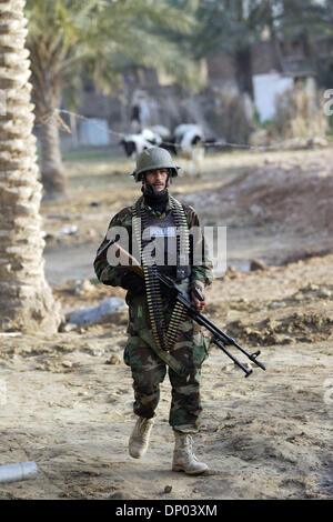 Feb 28, 2006; vicino a Ar Ramadi, Al Anbar, Iraq; un iracheno della polizia speciale Commando dal 2° Battaglione Brigata 2a, anche ampiamente noto come 'Wolf Brigata" di pattuglia in una zona rurale appena a nord della città irachena di Ar Ramadi su Feb 28, 2006. La polizia irachena sono stati su una missione congiunta con i soldati dal 101st airbourne in cerca di presunti insorti. Credito: Foto di Toby M Foto Stock