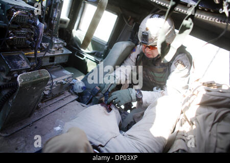 Feb 28, 2006; vicino a Ar Ramadi, Al Anbar, IRAQ; esclusivo! Noi Mags e TV chiamata 1-310-397-9165 o (949) 481- 3747 per il prezzo! Un esercito medic lavorare sulla mia gamba dopo ho avuto il mio femore in frantumi e caviglia rotta dal fuoco dei cecchini a nord della città irachena di Ar Ramadi su Feb 28, 2006, durante un pattugliamento comune che coinvolgono gli elementi dell'101st Airbourne assalto, e la polizia irachena 'Wolf Brigata.' Th Foto Stock