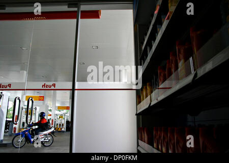 Mar 17, 2006; Jakarta, Indonesia; foto scattata da dentro il guscio Shop, un motociclo passa sopra ShellÕs vicino stazione di benzina con Shell lubrificanti fila in rack. Shell è la prima società estera che apre la stazione di benzina in Indonesia. Fino adesso Shell ha aperto tre stazioni di benzina a Jakarta. I piani della shell per build 400 stazioni di benzina in Indonesia entro otto anni. Obbligatorio Foto Stock