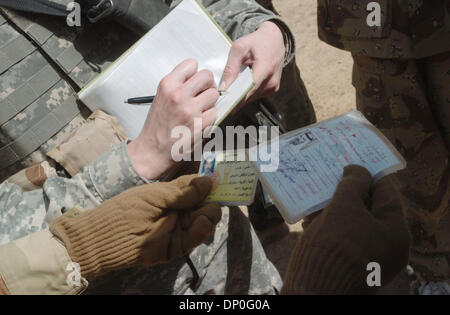 Mar 18, 2006; Saluhiddin, IRAQ; soldati di truppa C, 2-9 Cavalleria confronto carte di identificazione di un sospetto di insorti durante l'operazione Swarmer Marzo 18, 2006. L'uomo, presumibilmente la cavalleria squadrone più ricercati del ribelle, e uno dei suoi fratelli è stato successivamente detenuti. Quasi 1.500 US e soldati iracheni, 50 attacchi e il trasporto di elicotteri e 200 veicoli di terra erano fuori durante il Foto Stock