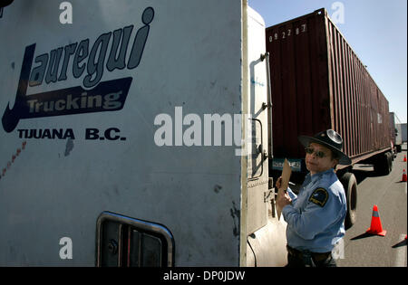 Mar 22, 2006; Otay Mesa, CA, Stati Uniti d'America; CHING YANG, un California Air Resources Board rappresentante del campo II colloqui con il conducente di un autocarro da Tijuana a California Air Resources Board e CHP stazione di ispezione sul Sempre viva per unità. È ammessa la opacità (densità di fumo) dei gas di scarico è un massimo del 10-15 per cento per i motori più vecchi e 5 percento su quelli più recenti. Il carrello ha superato il Foto Stock