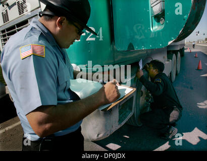 Mar 22, 2006; Otay Mesa, CA, Stati Uniti d'America; California Air Resources Board ispettori, VALENTE ARMENTA, sinistra e SAL ALATORRE, destra, ispezionare il motore di identificazione su un carrello diesel a California Air Resources Board e CHP stazione di ispezione sul Sempre viva per unità. Il motore di questo carrello è stato fabbricato tra 1993-1998 e doveva avere il suo programma per computer ricalibrato. Essa non aveva Foto Stock