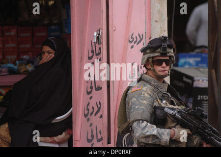 Apr 01, 2006; Bayji, Saluhidin, Iraq; una donna irachena si copre la faccia all'interno di un negozio mentre Spc. NICHOLAS ROGERS, un fante in Abu Co., prima della 187th fanteria, durante una pattuglia di Bayji, Iraq, su Aprile 1, 2006. Credito: Foto di Bill Putnam/ZUMA premere. (©) Copyright 2006 da Bill Putnam Foto Stock