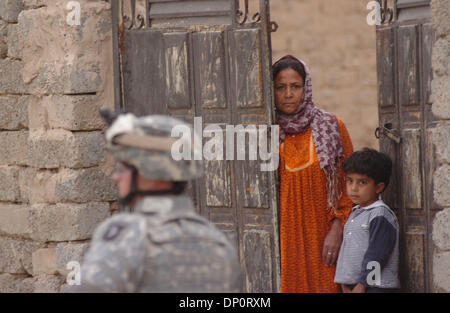 Apr 01, 2006; Bayji, Saluhidin, Iraq; una donna irachena e suo figlio guarda un fante da Abu Co., prima della 187th fanteria, passare dalla sua casa durante una pattuglia attraverso Bayji, Iraq, su Aprile 1, 2006. Credito: Foto di Bill Putnam/ZUMA premere. (©) Copyright 2006 da Bill Putnam Foto Stock