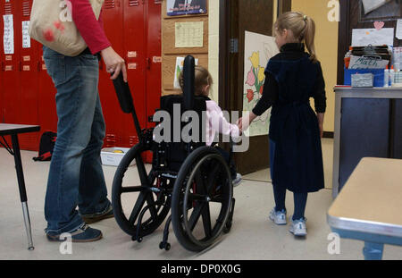 Apr 06, 2006; internazionale cade, MN, Stati Uniti d'America; (da sinistra a destra) Personal care assistant Danni Kallerman spinge speranza Moss la sedia a rotelle come kindergarten classmate Svetlana Zastavskiy Moss prende la mano come la classe si sposta in un'altra camera cade a scuola elementare per attività. All'inizio di giornata scolastica, Zastavskiy portato Moss una carta dicendo "speranza non si ammalano più." M Foto Stock