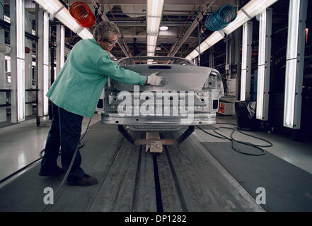 Apr 13, 2006; Detroit, MI, Stati Uniti d'America; (file foto: data esatta 07-29-2001) Chrysler per vendere beni di produzione da Sterling Heights impianto di assemblaggio. Nella foto: Gorgi Petreski, un metallo repairman, leviga il guscio di argento di un nuovo 2001 Chrysler Sebring all'inizio della linea di produzione dopo il robot saldatori hanno rafforzato i giunti. Il nuovo modello anno la produzione è beginn Foto Stock