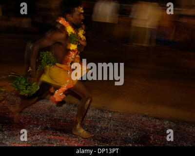 Apr 14, 2006; di Chennai, nello Stato del Tamil Nadu, India; con il bambino in mano, un devoto di Amman corre attraverso carboni ardenti. Essi ritengono che tutte le loro preghiere sarà risposto. Credito: Foto di Daniel Wilkinson/Daniel Wilkinson. (©) Copyright 2006 da Daniel Wilkinson Foto Stock