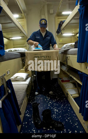 Apr 20, 2006; San Diego, CA, Stati Uniti d'America; (32nd St. Naval Station) US Navy seaman BRODY MATTHEWS ferri da stiro le vesti su un legless asse da stiro puntellato tra due cuccette in uomini per le operazioni di approdo a bordo della USS Rushmore. Per una storia sulla nuova caserma di lusso essendo costruito in occasione della trentaduesima San Naval Station. Il progetto avrà un costo di 300 milioni di dollari e includono quattro 18-storia torri, tra cui uno Foto Stock