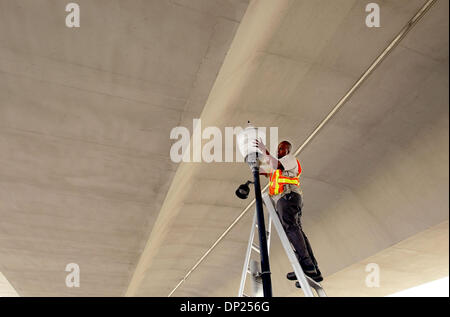 Maggio 16, 2006; Stuart, FL, Stati Uniti d'America; Mike Hazelton, con la città di Stuart Opere Pubbliche Dipartimento, tenta di fissare un nuovo mondo di plastica su una lampada posta sul Dixie Highway dove la strada corre sotto il ponte di Roosevelt in Stuart. Hazelton e compagni di città dipendente Michael Trapani sono state la sostituzione di vari globi intorno all'area del centro cittadino. Credito: Foto di Paul J. Milette/Palm Beach Foto Stock