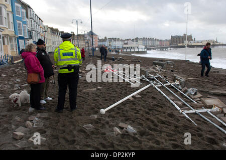 Aberystwyth, UK. Il 7 gennaio 2014. I lavori di riparazione va avanti come il Victorian cittadina balneare di Aberystwyth entra nel quinto giorno di essere battuto da onde enormi e tempesta venti della forza risultante da una mareggiata associato con un sistema di bassa pressione che si trova a nord-ovest della Scozia. Credito: Graham M. Lawrence/Alamy Live News. Foto Stock