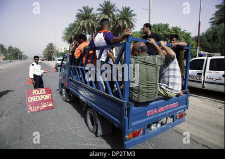 Giu 11 2006, Baghdad, Iraq; un truckload di civili iracheni lavoratori passano attraverso un traffico casuale checkpoint a Baghdad la zona verde. La zona internazionale, conosciuta anche come la zona verde, si trova a 5 miglio quadrato di area di Baghdad che contiene la Nazionale Irachena e del governo di coalizione del Primo Ministro iracheno di ufficio, Ministero iracheno della difesa, e degli Stati Uniti e le forze della coalizione ambasciate. t è un Foto Stock