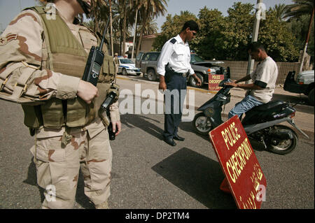 Giu 11 2006, Baghdad, Iraq; un soldato americano e un poliziotto iracheno fare si ferma a un traffico casuale checkpoint a Baghdad la zona verde. La zona internazionale, conosciuta anche come la zona verde, si trova a 5 miglio quadrato di area di Baghdad che contiene la Nazionale Irachena e del governo di coalizione del Primo Ministro iracheno di ufficio, Ministero iracheno della difesa, e degli Stati Uniti e le ambasciate di coalizione. Foto Stock