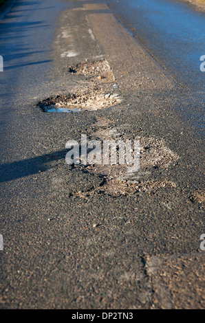 Primo piano di buche sulla strada in inverno Inghilterra Regno Unito Regno Unito Gran Bretagna Gran Bretagna Foto Stock