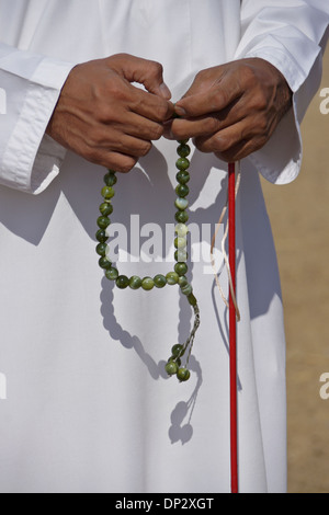 Uomo musulmano in abito tradizionale con grani di preghiera, Al-Ain, Abu Dhabi, Emirati Arabi Uniti Foto Stock