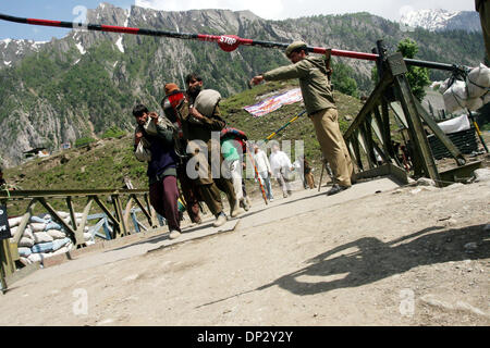 Jun 13, 2006; Kashmir India; l'annuale pellegrinaggio alla grotta santuario di Amarnath sono rimaste in sospeso per il terzo giorno come le frane bloccando le rotte da Batal e Pahalgam al santuario non poteva essere cancellato. Un poliziotto sorge lungo una barriera a Baltal base camp come piligrims indù iniziano il loro percorso trekking fino a raggiungere Santa Grotta di Amarnath situato a 3880 m sopra il livello del mare in lui Foto Stock