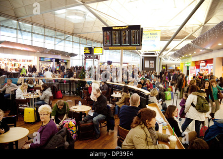 Stansted airport lounge di partenza; affollate di persone che viaggiano; Essex, Inghilterra, Regno Unito Foto Stock