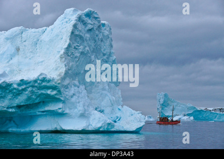 I turisti in barca da pesca tra gli iceberg nella baia di Disko, Ilulissat, Groenlandia occidentale Foto Stock