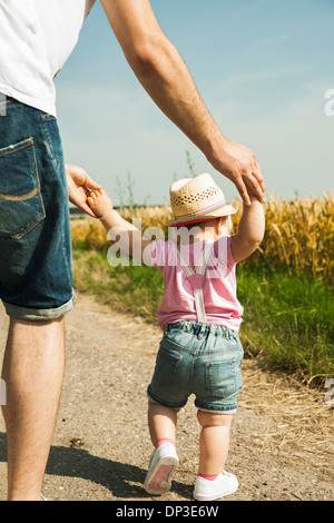 Padre e figlia bambino passeggiate all'aperto, Mannheim, Baden-Württemberg, Germania Foto Stock