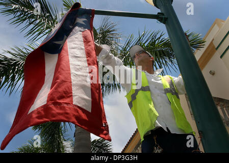 Jul 05, 2006; Delray Beach, FL, Stati Uniti d'America; Adan Perez della città di Delray Beach Opere Pubbliche Dipartimento rimuove uno dei 30 banner da un palo della luce lungo Atlantic Avenue, mercoledì mattina. Egli fu la commutazione della bandiera banner torna allo standard villaggio sul mare banner. Credito: Foto di Bob Shanley/Palm Beach post/ZUMA premere. (©) Copyright 2006 da Palm Beach post Foto Stock