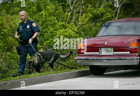 Jul 05, 2006; Porta St. Lucie, FL, Stati Uniti d'America; K-9 Officer Tom Eisert e Taz cerca per un sospetto coinvolto in un portamonete rapina dietro la porta est Plaza in corrispondenza della zona di spigolo di Walton e Autostrada Federale il mercoledì pomeriggio. Uno dei due sospetti è stato fermato. Il veicolo è coinvolto nella foto a destra. Credito: Foto di Amanda Voisard/Palm Beach post/ZUMA premere. (©) Copyright 2006 Foto Stock