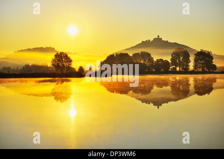 Il castello di Wachsenburg con nebbia di mattina e il sole che riflette nel lago all'alba, Drei Gleichen, Turingia, Germania Foto Stock