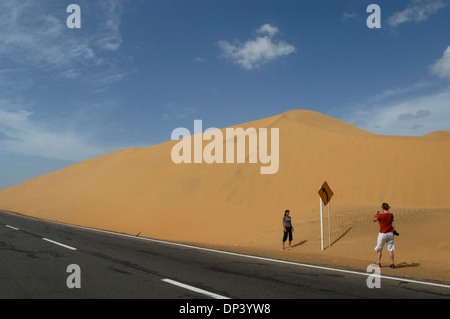 I turisti scattare foto in prossimità di un segno di traffico in una duna di sabbia in coro, penisola di Paraguanà, Venezuela Foto Stock