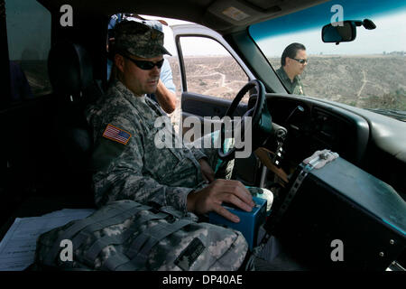 Jul 19, 2006; San Diego, CA, Stati Uniti d'America; DANIEL MARKERT della California Natiional orologi di guardia la recinzione di confine su un monitor in una pattuglia di confine carrello da una collina ad est di San Ysidro porto di entrata noto come Arnie's punto. Protezione nazionale della California è di aiutare a proteggere gli Stati Uniti-Messico frontiera per la costruzione di strade e osservando il confine attraverso il calore sensibile degli ambiti. Credito obbligatorio Foto Stock