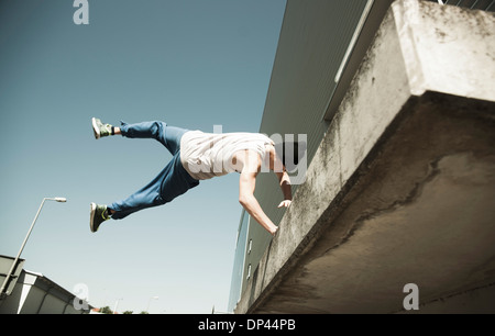 Basso angolo vista del ragazzo adolescente facendo handstand sul balcone, freerunning, Germania Foto Stock