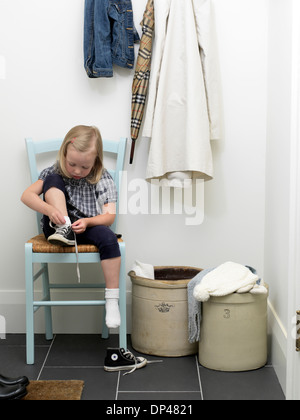 Ragazza scarpe di legatura in corridoio anteriore, Toronto, Ontario, Canada Foto Stock