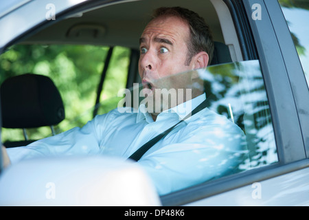 Imprenditore sorpreso la guida auto, Mannheim, Baden-Württemberg, Germania Foto Stock