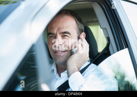 Imprenditore utilizzando il telefono cellulare mentre si guida, Mannheim, Baden-Württemberg, Germania Foto Stock