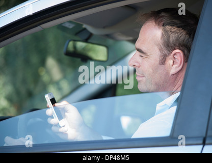 Imprenditore utilizzando il telefono cellulare mentre si guida, Mannheim, Baden-Württemberg, Germania Foto Stock