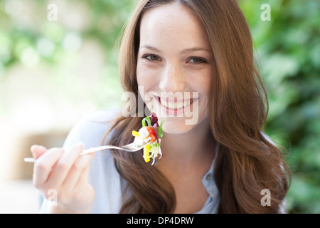 Giovane donna di mangiare un insalata Foto Stock