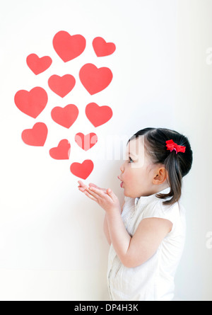 Bambina di tre anni baci di soffiatura Foto Stock