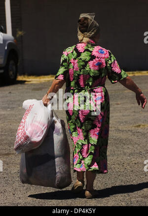 Aug 16, 2006; Sacramento, CA, Stati Uniti d'America; un 'mobile mall' abbigliamento libero giveaway di bisognosi residenti di Sacramento è il frutto del Padre Dan Madigan, fondatore del Sacramento Food Bank. Il premio si è tenuta mercoledì, 16 agosto 2006 nel Del Paso Heights quartiere. Una donna lascia con una grande selezione di articoli. Chiunque potrebbe prendere quanto necessario. Credito: Foto Foto Stock