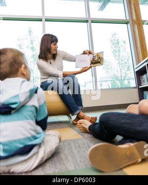 Insegnante che mostra foto libro per gli studenti Foto Stock