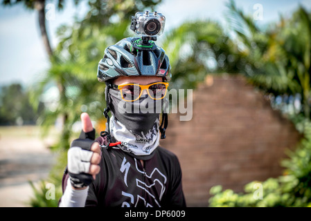 Fotocamera GoPro. Concorrente in bicicletta che indossa una videocamera digitale GoPro Hero 3 montata su casco per registrare il suo evento. Thailandia S. E. Asia Foto Stock