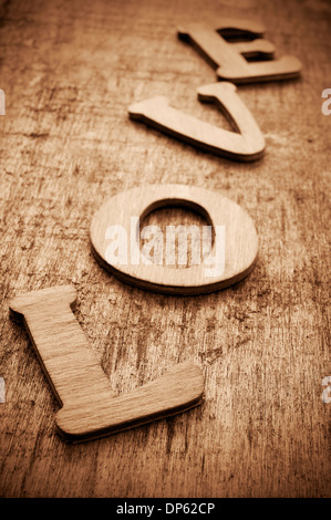 Lettere di legno costituente la parola amore su un vecchio superficie in legno Foto Stock