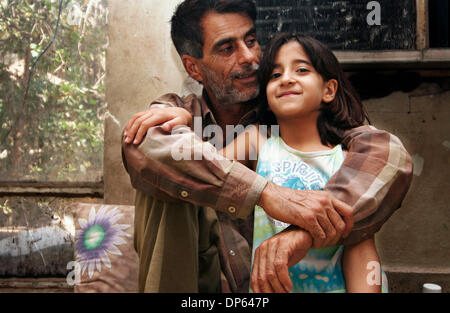 Ott 06 2006, Baghdad, Iraq; un uomo iracheno e sua figlia Siediti sul pavimento della loro casa di fortuna in un capannone per il rimessaggio per motivi di Saddam Hussein teatro personali a Baghdad. Diverse famiglie irachene, spostato dopo il 2003 invasione, cercato rifugio nei resti di Saddam Hussein teatro personali, costruito per intrattenere l'ex presidente iracheno durante la sua regola. Le famiglie Foto Stock