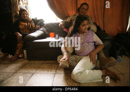 Ott 06 2006, Baghdad, Iraq; un soldato americano trecce un iracheno ai capelli della ragazza nelle rovine di Saddam Hussein teatro personali a Baghdad. Spostato durante il 2003 invasione, la ragazza e la sua famiglia vive nel guscio del teatro insieme con diverse altre famiglie. Il teatro fu costruito per intrattenere l'ex presidente iracheno con giochi e spettacoli durante la sua regola. Il famili Foto Stock